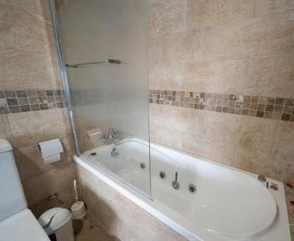 Bañera de hidromasaje privada en el baño de este coqueto apartamento rural.